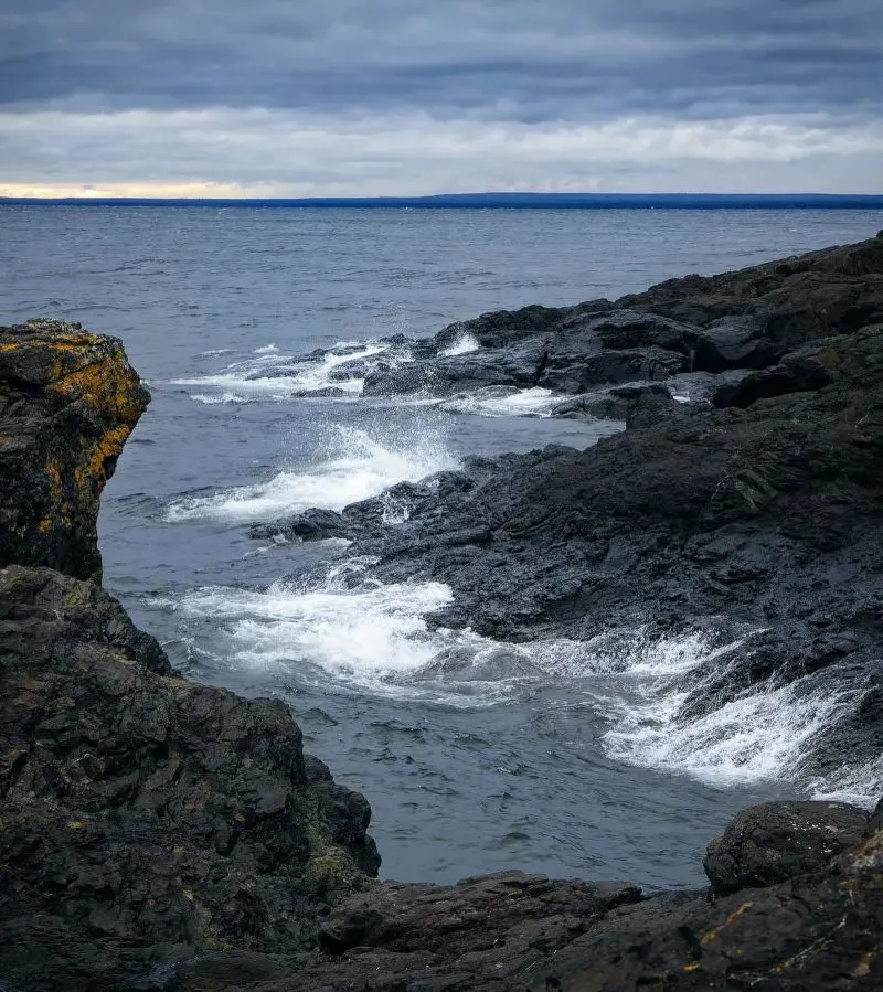 A beautiful scene in Marquette with a structure amid the water. 